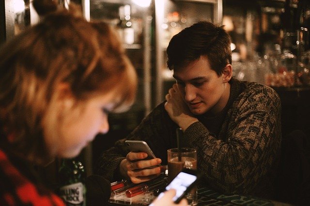 Muž a žena, mladí ľudia v kaviarni, mobily.jpg